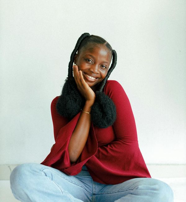 Smiling woman sitting in a comfortable cross-legged position.